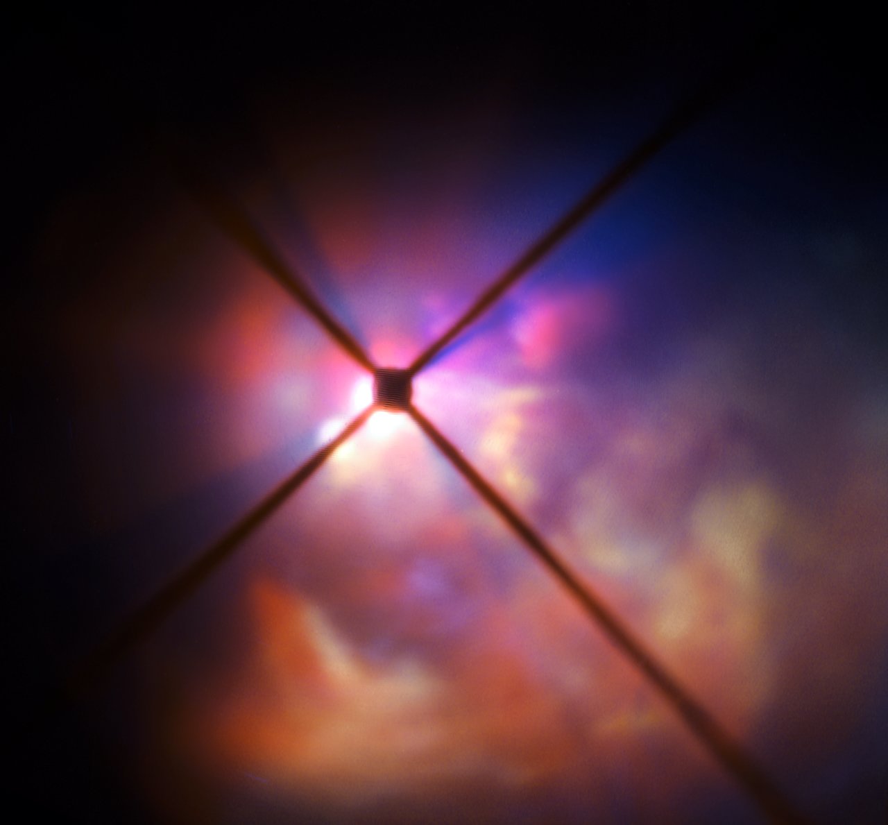 A dark central disc surrounded by bright, lumpy clouds of reflected light