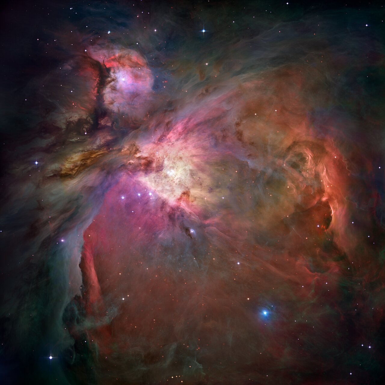 The Orion Nebula: glowing clouds of red, orange and blue gas around a bright central cluster